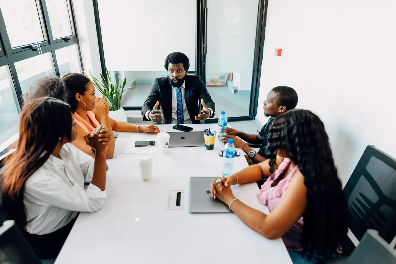 Team of young Nigerian professionals in a meeting around a table in a bright office